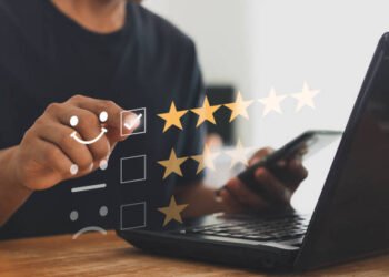 Online customer service and satisfaction survey concept with internet technology. Finger of businessman touching and check mark icon face emoticon smile, service mind, service rating. Work from home.